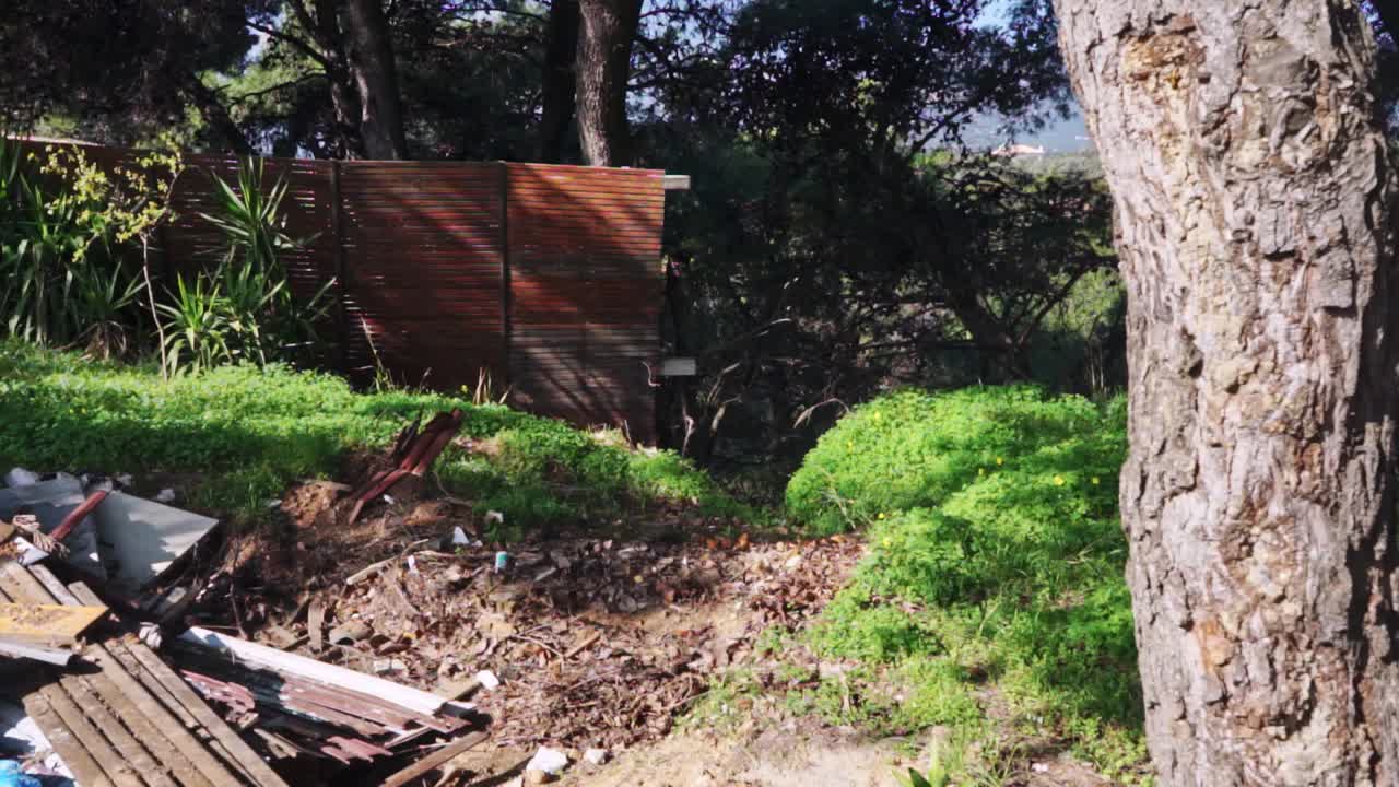 Pan shot of equipment debris, left at foot of Parmitha mountain, Athens, Greece