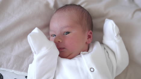 Funny infant. Adorable newborn baby sleeping and yawning on bed. Lovely toddler at home. Close-up