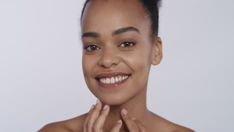 Retrato-Hermosa-Mujer-Afroamericana-Tocando-La-Cara-Con-Las-Manos-Acariciando-Una-Piel-Suave-Y-Saludable-Disfrutando-De-Una-Belleza-Natural-Perfecta-Sobre-Fondo-Blanco.