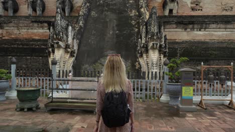 jovem caminhando em direção às escadas do templo wat chedi luang - chiangmai, tailândia