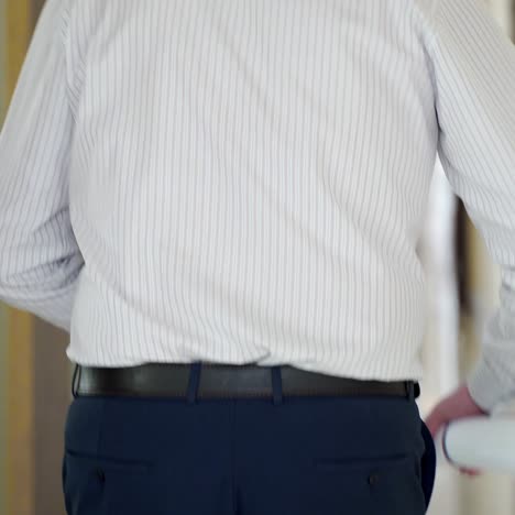 an employee with papers is running along the corridor to his workplace. late to office