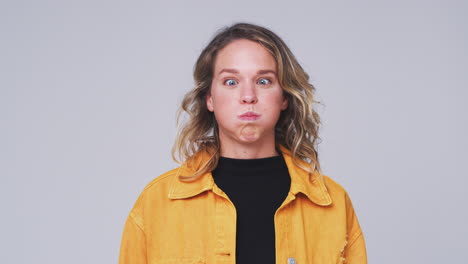 Head-And-Shoulders-Studio-Shot-Of-Woman-Pulling-Faces-And-Smiling-At-Camera-In-Slow-Motion