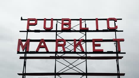 an isolated shot of the public market neon metal sign with an overcast sky in the background at the famous pike place market in seattle, washington