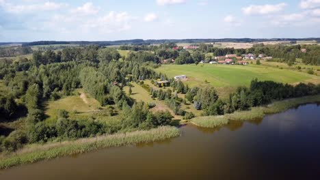 Aerial-shot-of-a-secluded-lake,-surrounded-by-fields-and-farms