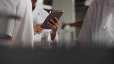african american female chef using tablet in restaurant kitchen