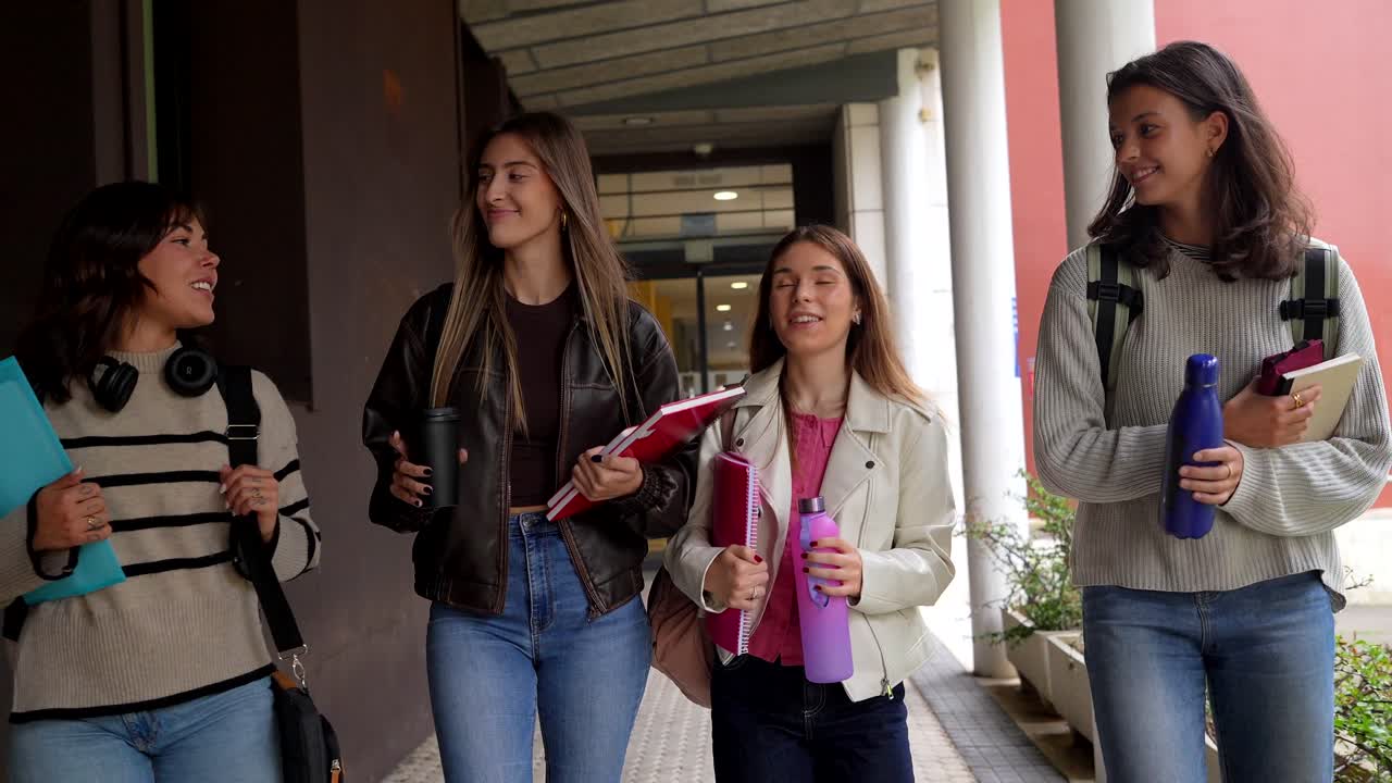 Quattro giovani studentesse che camminano e parlano nel campus universitario