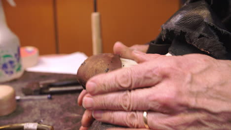 bespoke shoemaker pinning leather together to make shoe