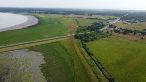 Drone-shot-road-cutting-through-beautiful-wild-nature-in-Denmark