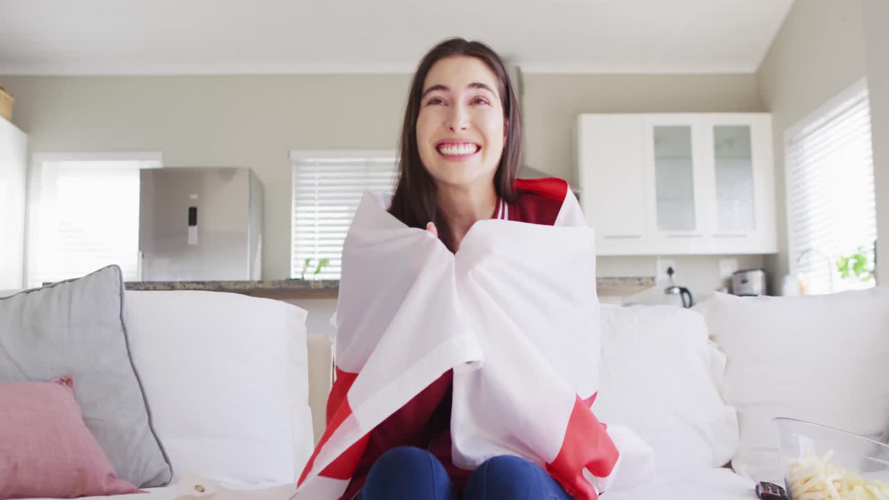 미국  ⁇ 발과 함께 소파에 앉아서 거실에서 tv를 보는 행복한 백인 여성