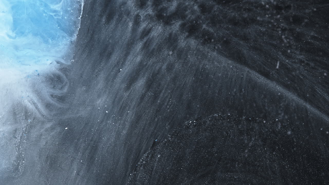 Ink mixing in water, macro view showing colorful swirls and fluid textures
