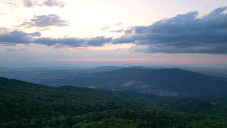 inclinar hacia abajo aérea revela el valle a los pies de la montaña vitosha en el color del crepúsculo de verano