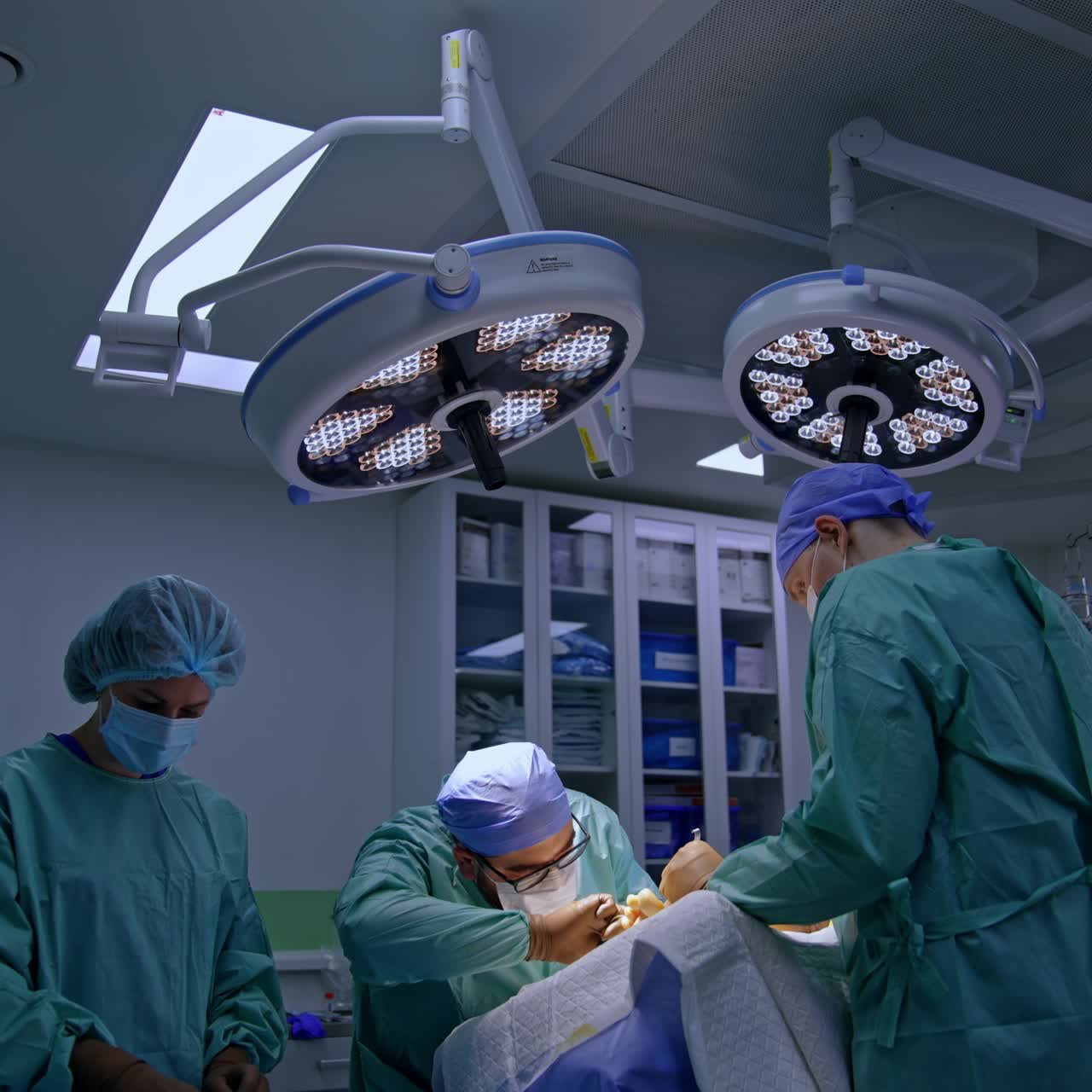 Professional surgeon performs operation on foot. Assisting doctor holds the instrument in a section. Nurse prepares materials