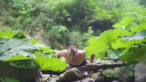 deportista haciendo flexiones en el arroyo en el bosque.