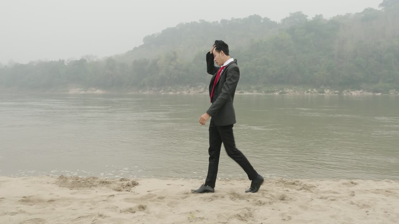 Businessman Walking Along Riverbank on a Foggy Day