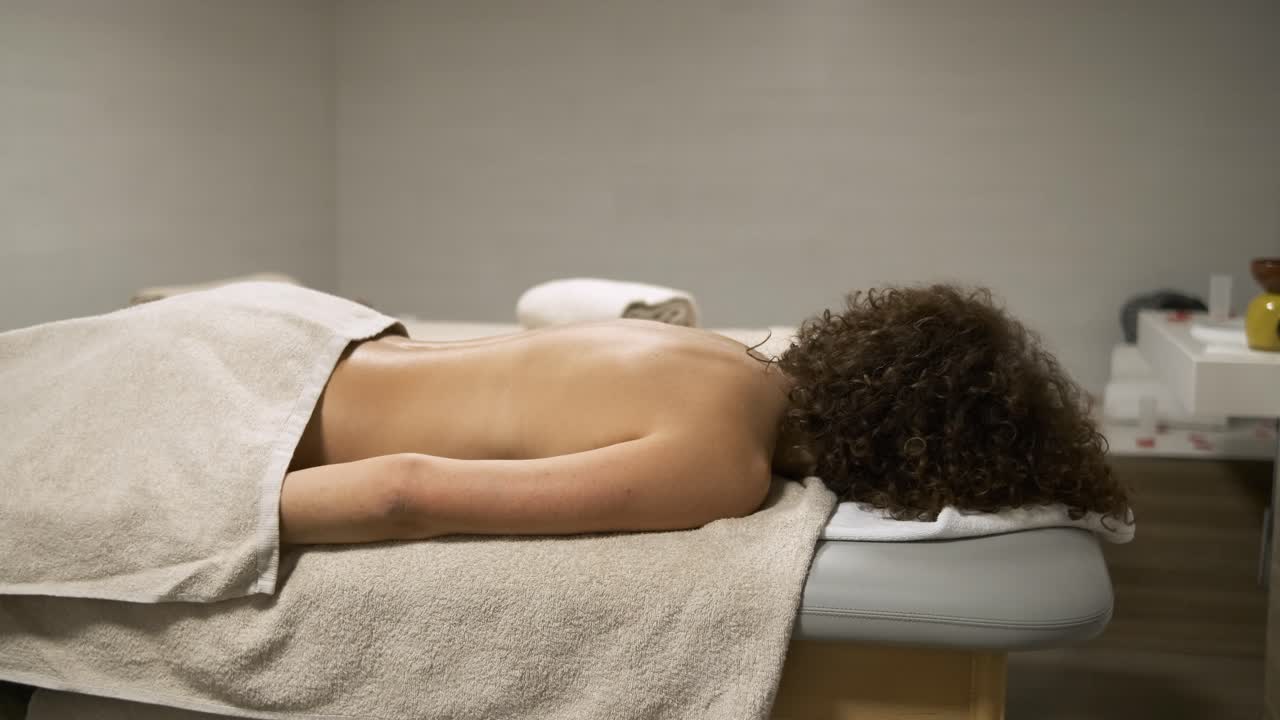 Woman enjoying a relaxing massage therapy session in a tranquil spa setting