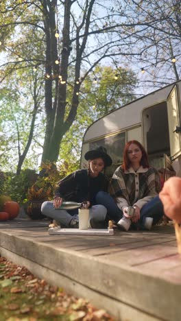 two friends enjoying a fall day by a campervan