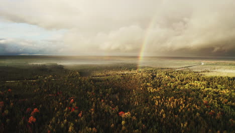 Un-Arco-Iris-Sobre-Un-Bosque-Otoñal-En-El-Norte-De-Michigan,-Disparo-De-Un-Dron