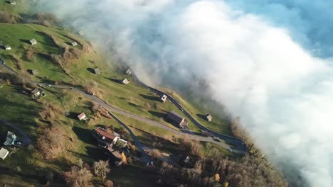 Curvy-road-network-runs-through-a-mountain-village-on-the-edge-of-a-slope-in-which-low-clouds-hang