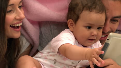 Parents-with-baby-daughter-using-tablet