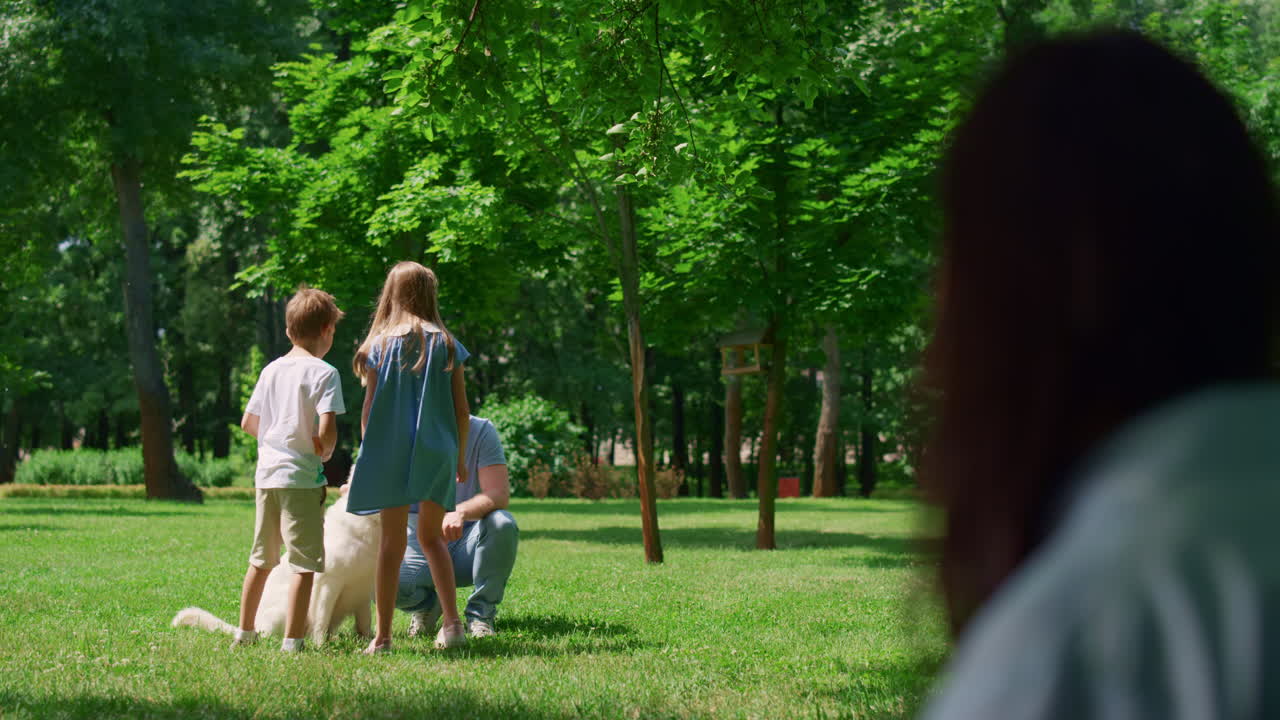 여름 피크닉에서 휴식을 취하는 가족을 찾는 알 수 없는 여성의 모호한 프로필.