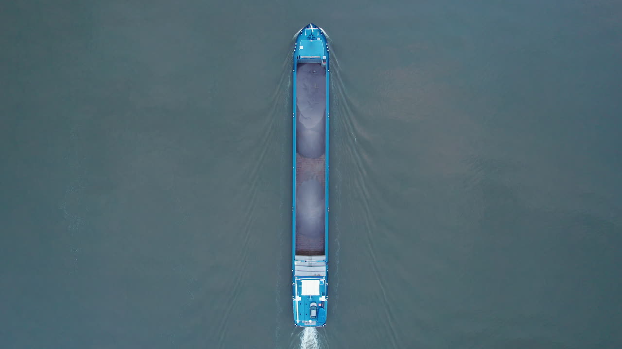 por encima de la toma de un dron de un buque de carga vacío que viaja río arriba en el río amer, países bajos