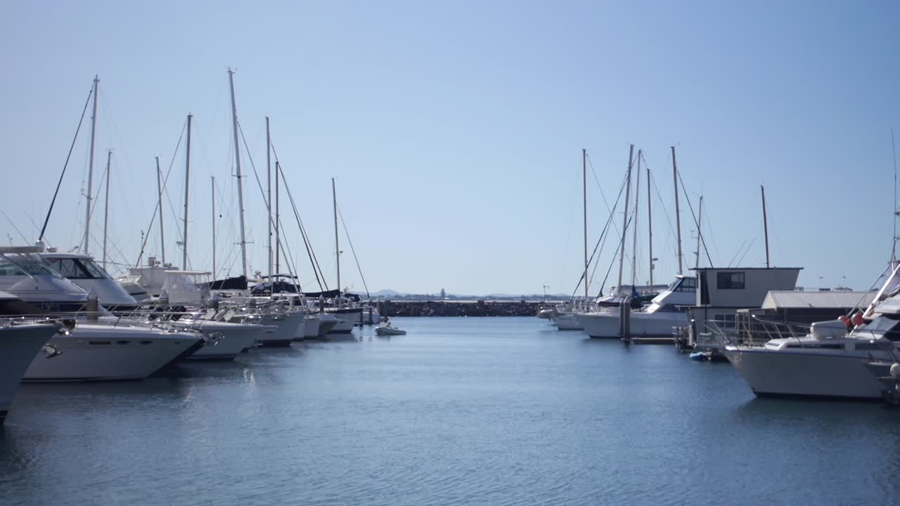 Speedboats moored at marina on blue sky day medium shot