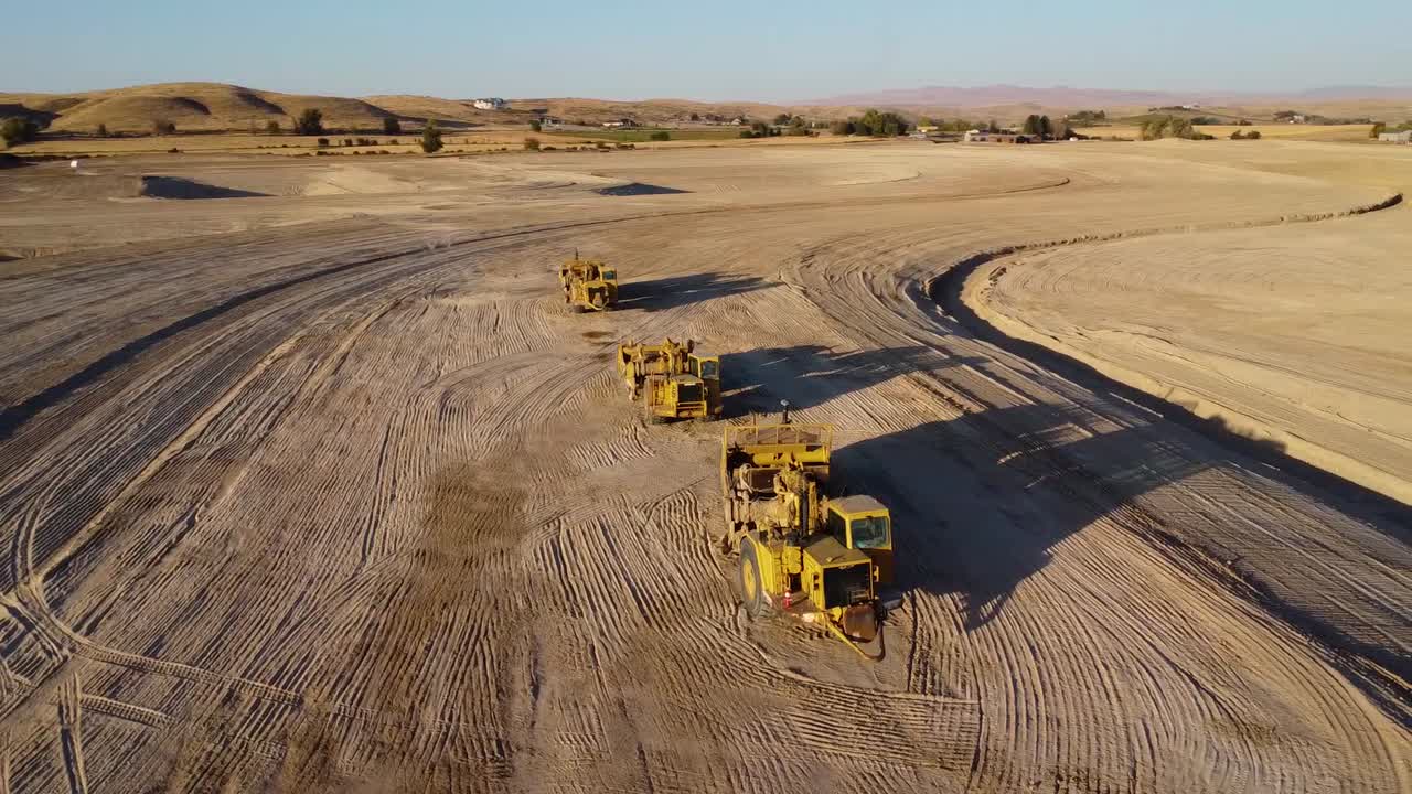video de un dron sobrevolando los raspadores de tournapull de excavación en el desierto