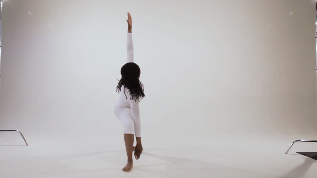 Black yogini moves from warrior poses to triangle pose