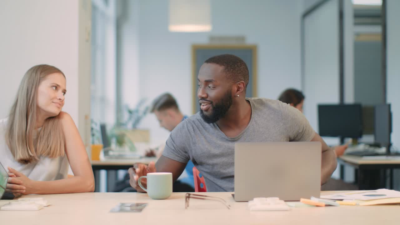 Business man sleeping with laptop. Smiling woman giving coffee to colleague.