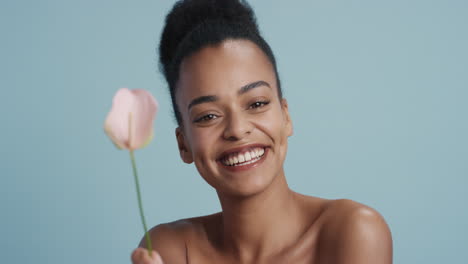 portrait beautiful young woman holding lily flower smiling enjoying healthy skincare happy female with perfect natural beauty on blue background
