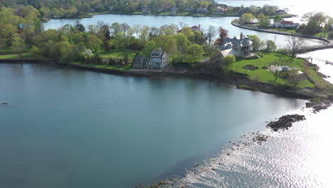 an aerial view over a quiet pond which is surrounded by green trees on a sunny day