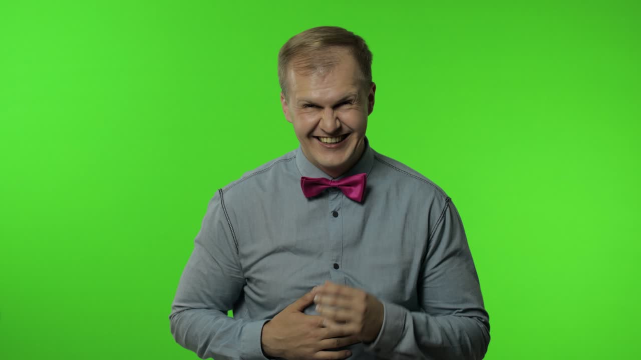 hombre sosteniendo el vientre y riendo en voz alta con lágrimas, sintiéndose despreocupado alegre después de escuchar un chiste gracioso