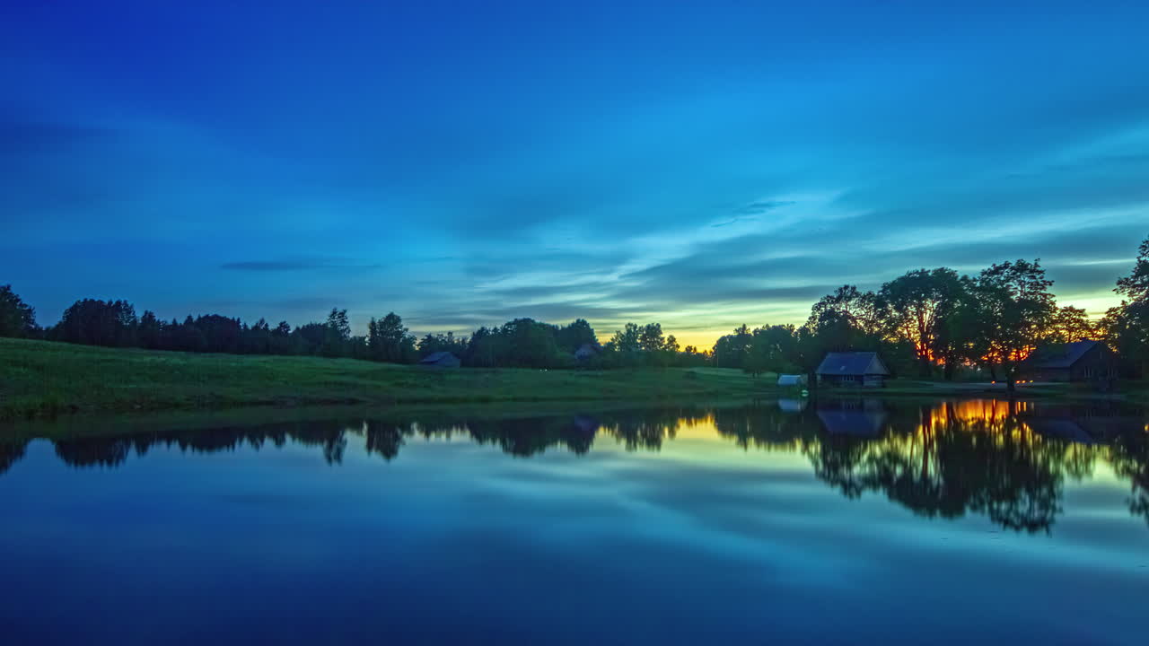 nubes que se mueven a través del cielo reflejadas en el lago pintoresco durante el colorido amanecer