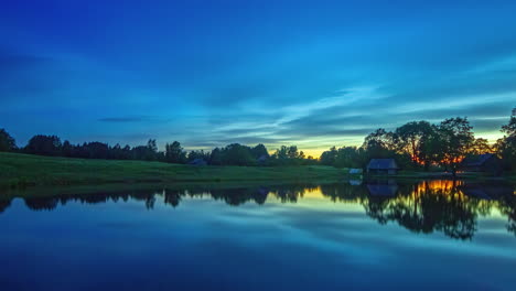 clouds moving across the sky reflected on scenic lake during colourful sun rise