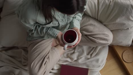 woman relaxing with tea and book