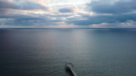 Ruhe-Einer-Meereslandschaft-Mit-Vorspringendem-Steg-Bei-Sonnenaufgang