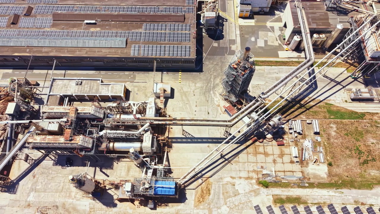 Sito industriale con strutture e tubazioni in un'area di produzione durante il giorno