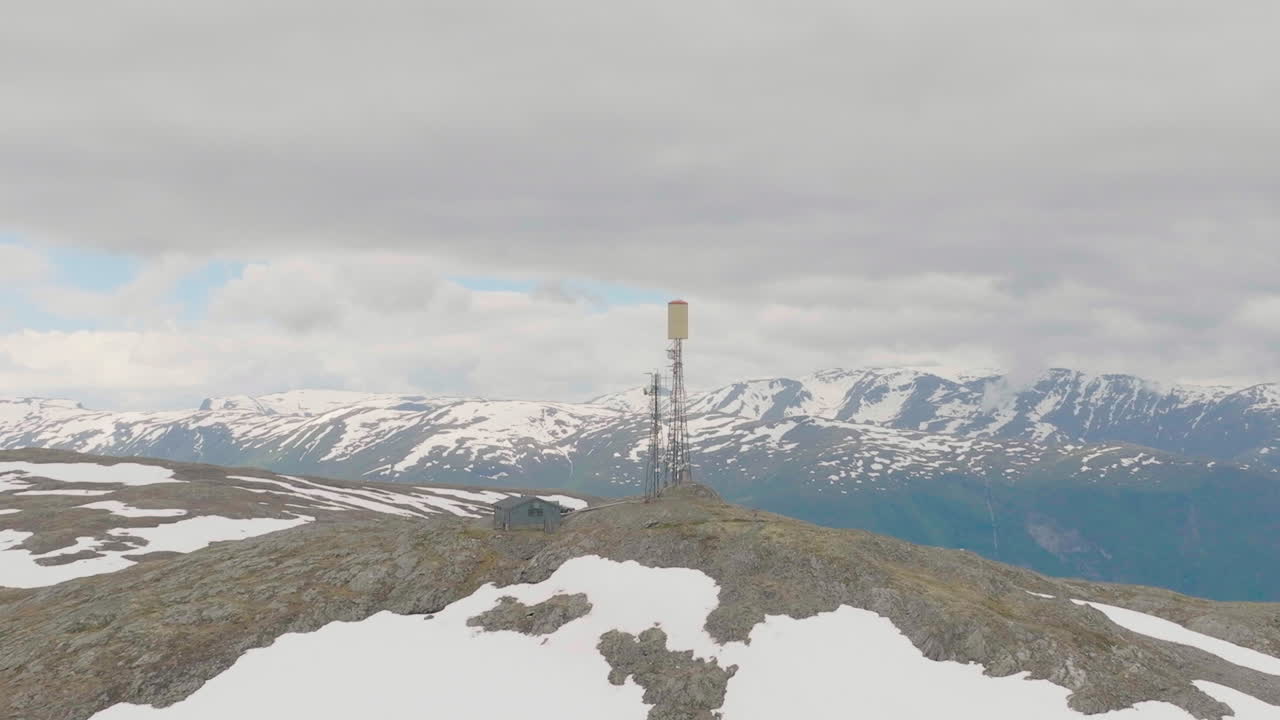 vista aérea panorámica del mástil telefónico en el pico de la montaña storhovd en noruega, disparo en órbita