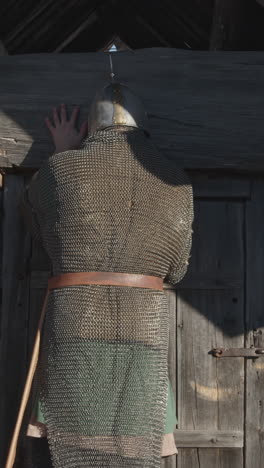 medieval soldier peering through a wooden door