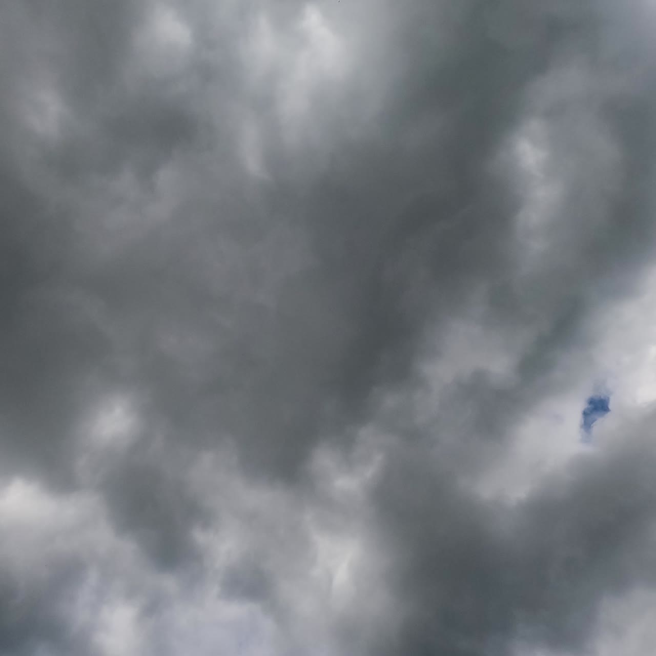 Dramatic cloudscape building in the atmosphere. Thick grey clouds forming heavy rain clouds. Low angle timelapse