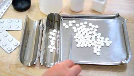comprimidos de medicamentos en la bandeja de conteo con la espátula de conteo