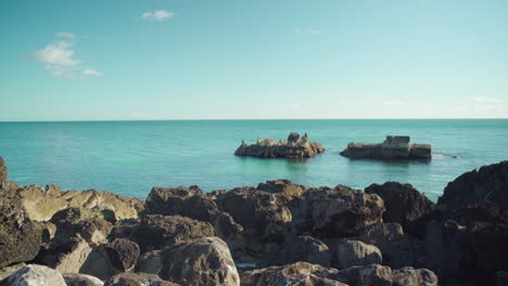 peaceful ocean view at shore with rock cliff with blue sky at cascais portugal 4k steady shot