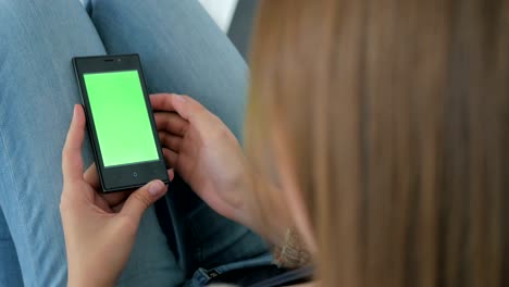 mujer usando un teléfono inteligente con pantalla verde