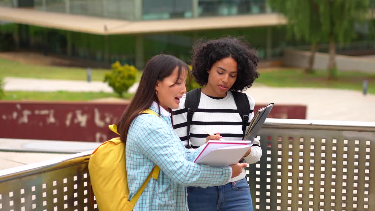 Due studentesse che discutono degli appunti nel campus