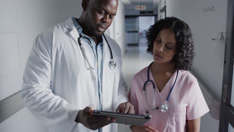 Portrait-of-happy-diverse-doctors-using-tablet-in-hospital-in-slow-motion