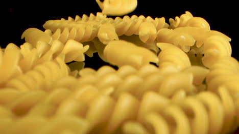 Slow-Motion,-Macro-Shot-Of-Falling-fusilli-on-black-mirror-surface