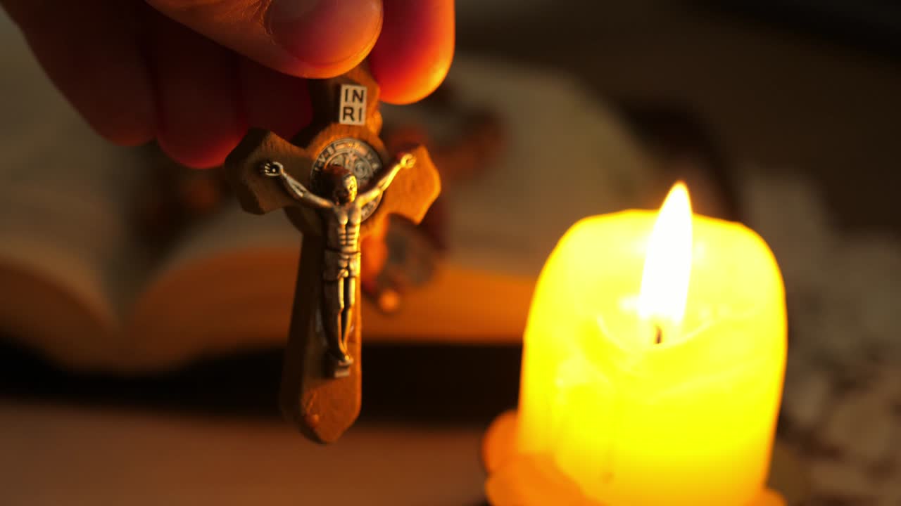 cruz con cristo jesús en el crepúsculo iluminado por la luz de la vela