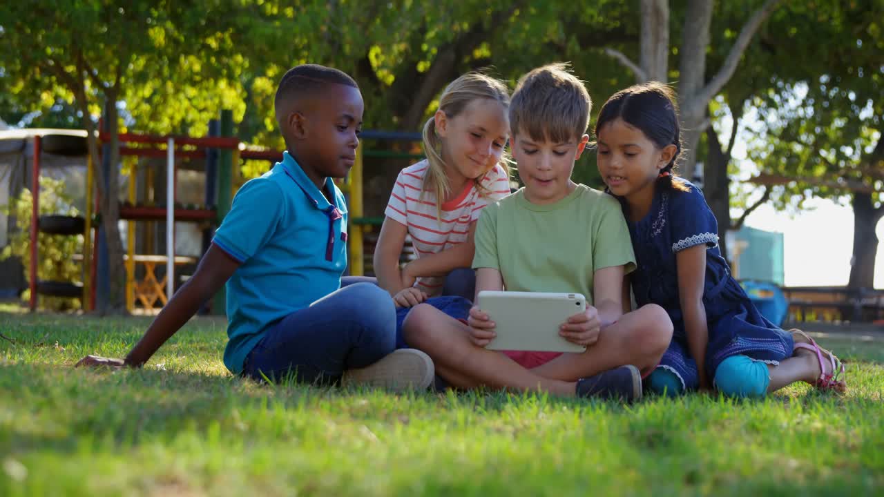 niños usando tableta digital en el patio de recreo 4k