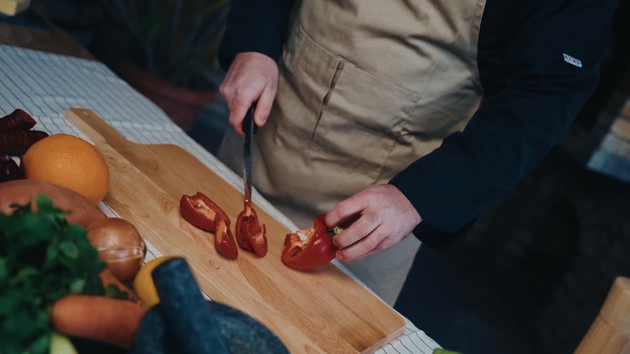신선 한 채소 로 둘러싸인 나무판 에 은 벨 페퍼 를 잘라내는 요리사