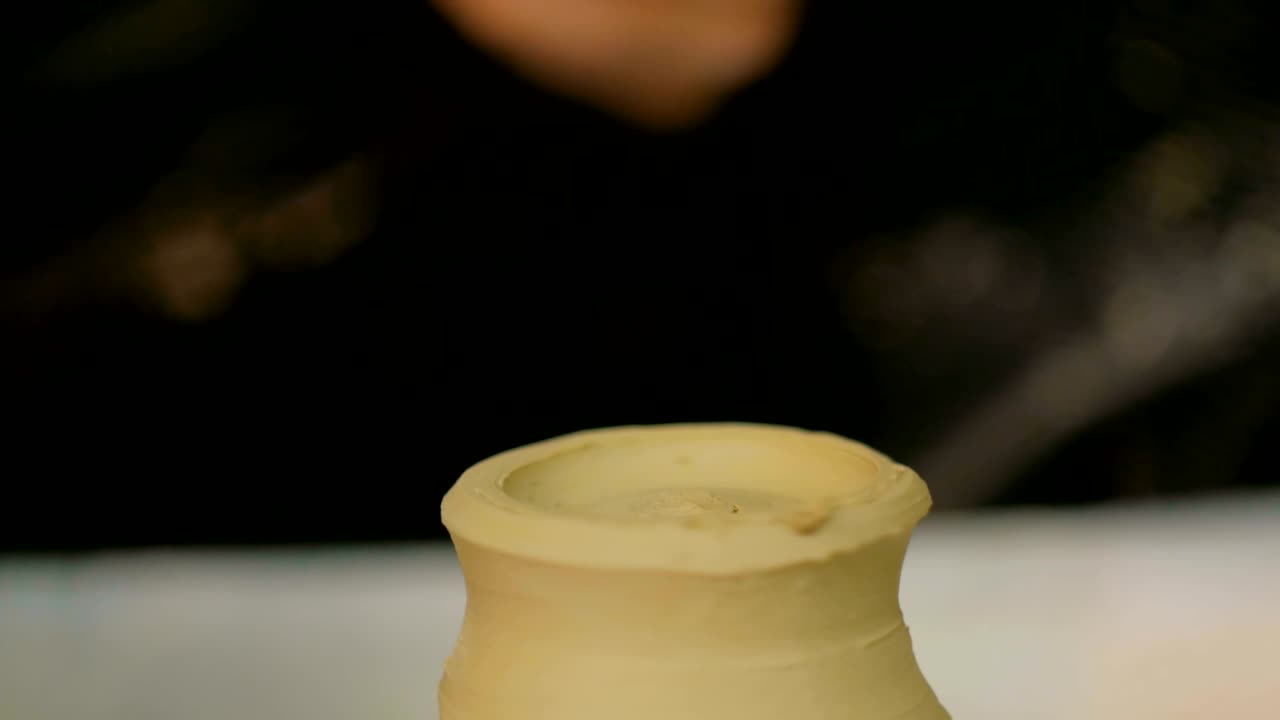 taza de conformación de alfarero profesional con herramienta especial en taller de cerámica